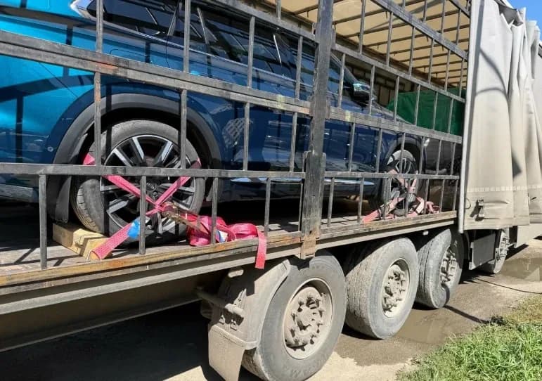 Колеса автомобиля в кузове, притянутые ремнями к полу