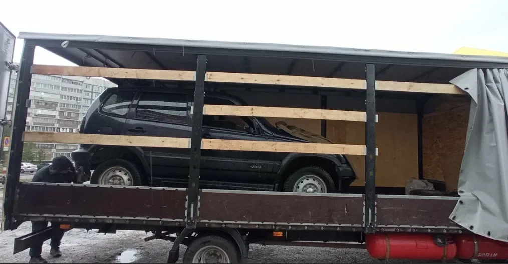 Внедорожник в кузове, закрепленный деревянными распорками